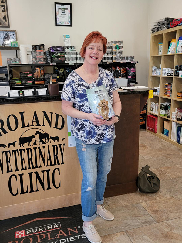 a woman stands confidently in front of a veterinary clinic